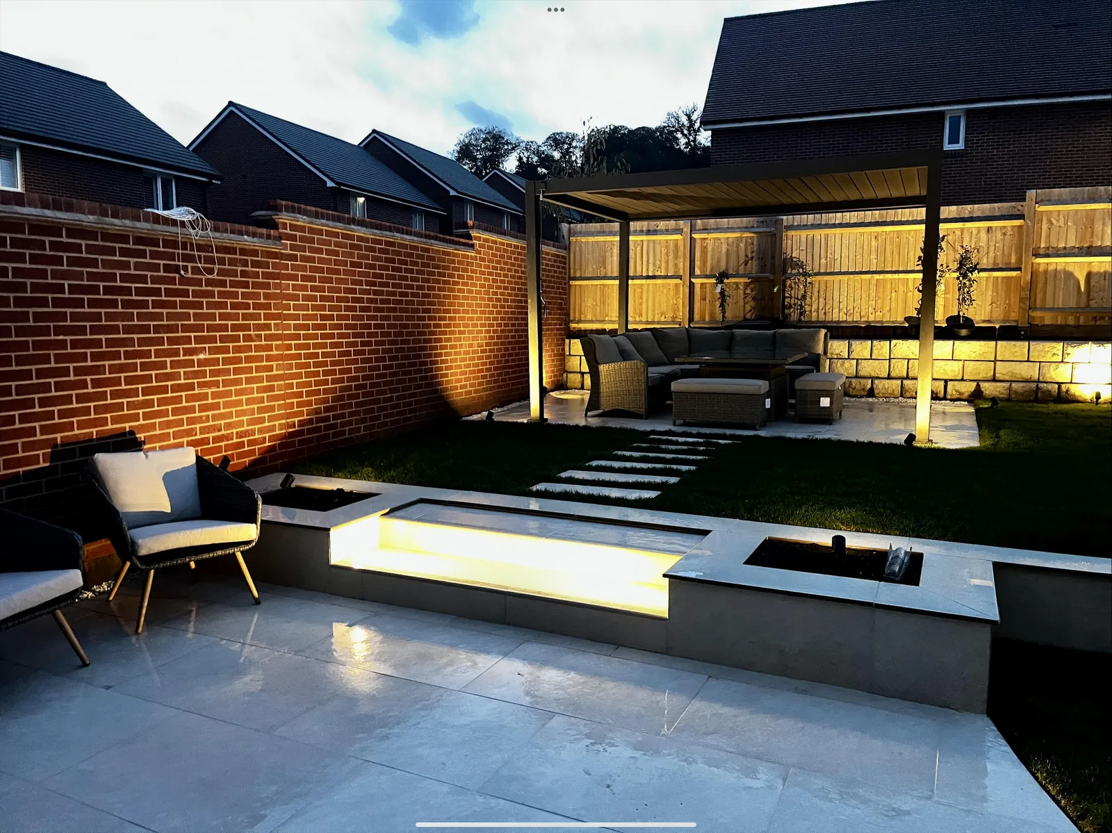 Multi-level HLS garden redesign with porcelain paving and integrated lighting in Hampshire